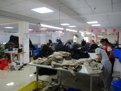 Quality control technician comparing a washed garment to an approved acid wash reference swatch
