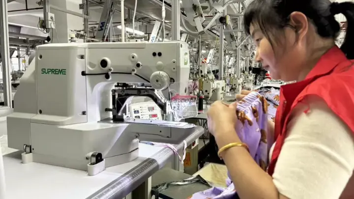 Bilingual English and French care label being attached on the production line