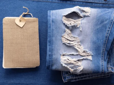 Finished distressed denim jeans with hand-sanded whisker fading