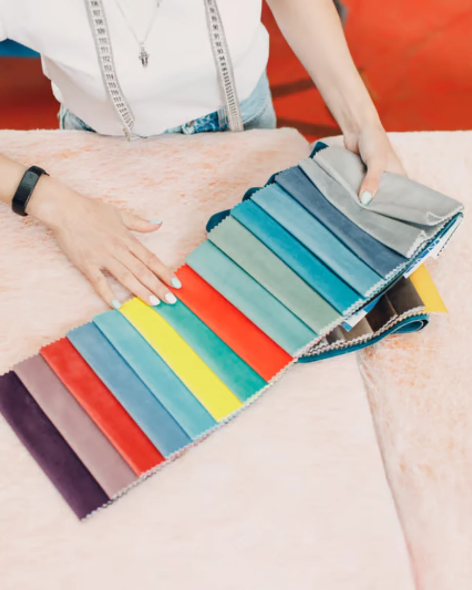 Open fabric swatch book with labeled GSM weight tags on each sample