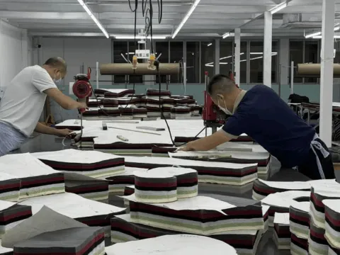 Laser finishing machine burning a whisker pattern onto denim fabric