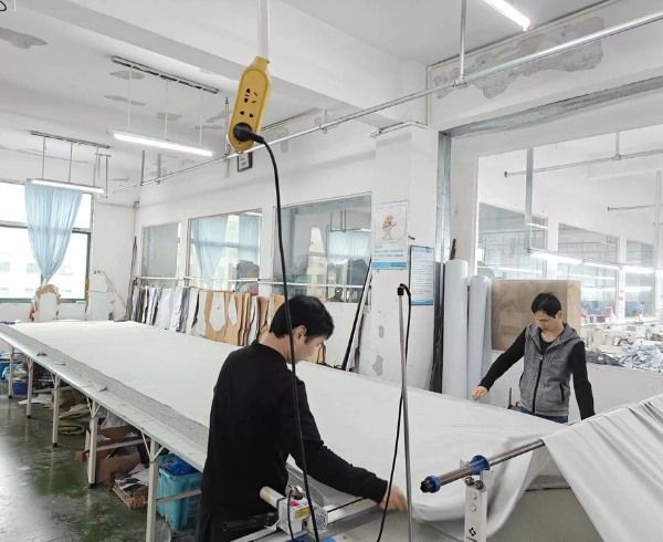 QC inspector performing four-point fabric inspection on denim fabric