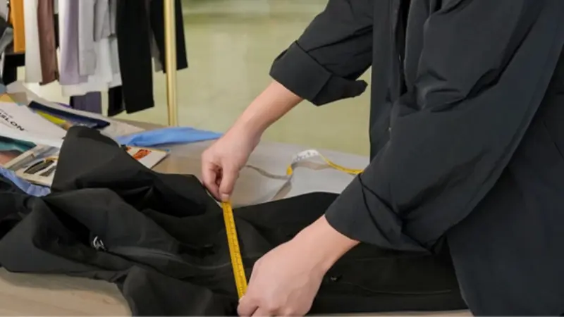 Sample garment being measured against spec sheet for quality check