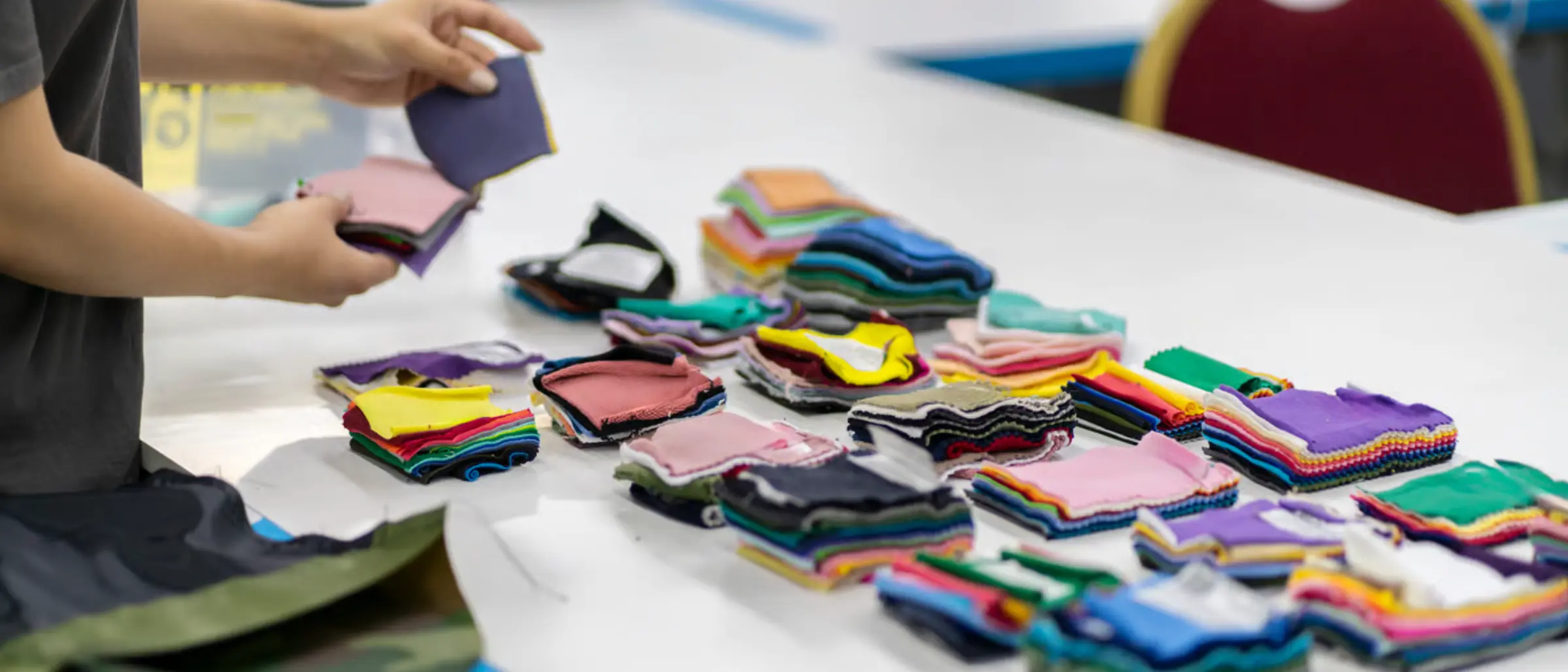 FORGEMFG technician inspecting custom fabric swatches for weight, texture and color
