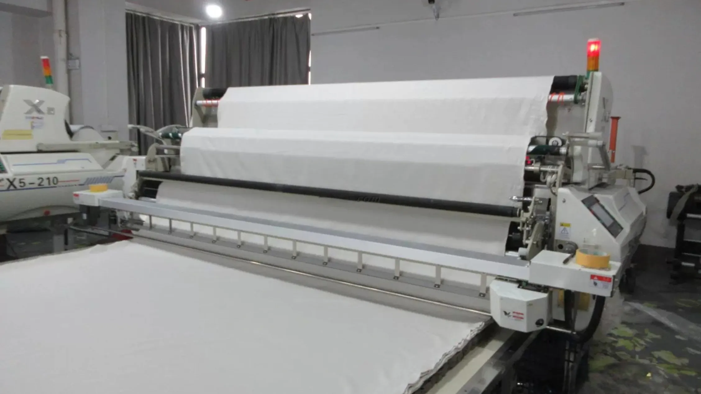 Inspector examining fabric on an illuminated inspection frame