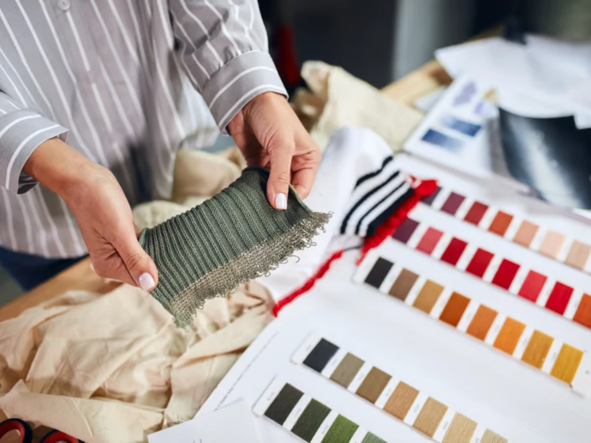 Textile technician inspecting a custom jacquard swatch for pattern alignment and yarn quality