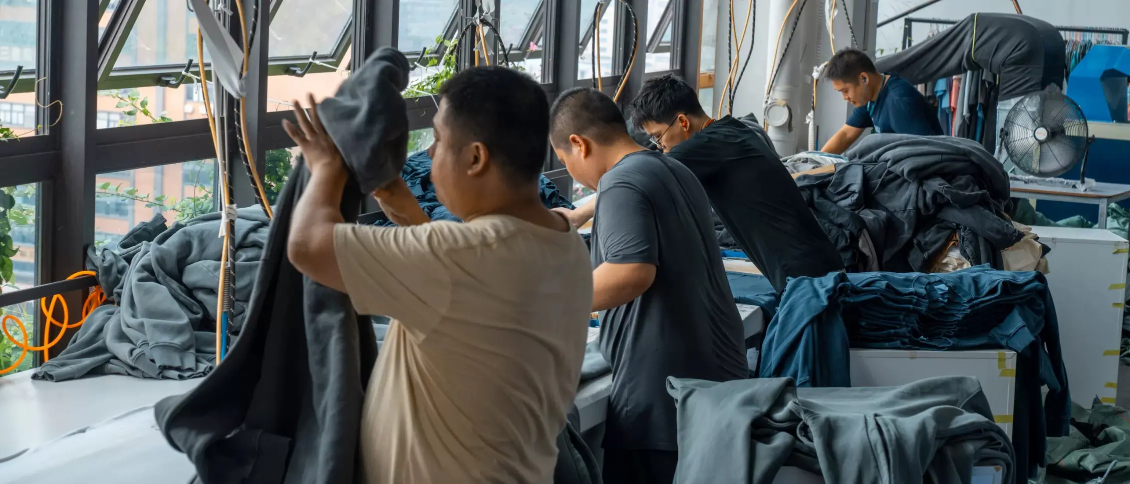 Quality control team inspecting garments from multiple finishing departments side by side