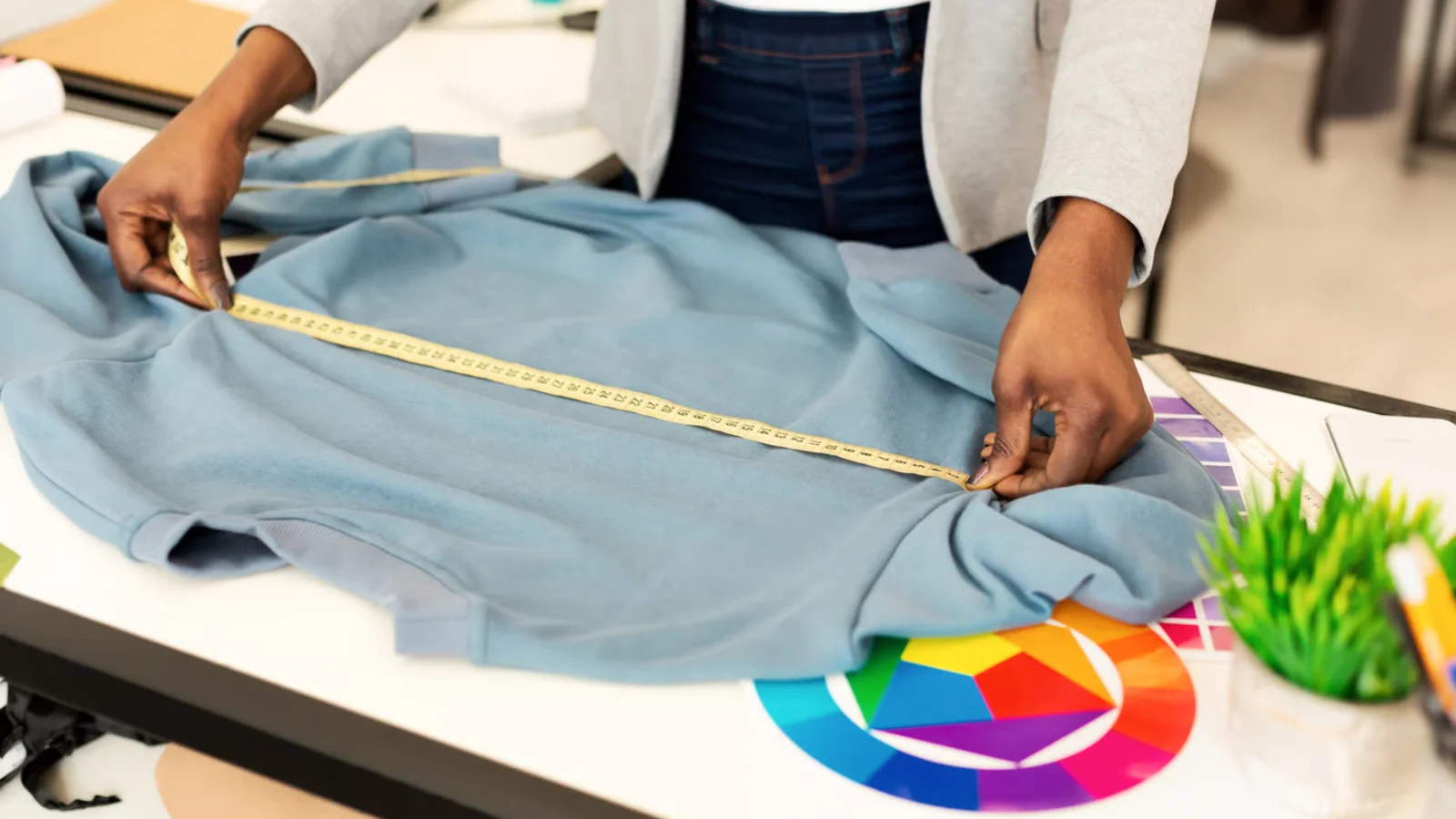 Sample t-shirt being measured against spec sheet